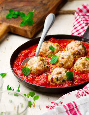 Chicken meatballs with tomato sauce in a frying pan